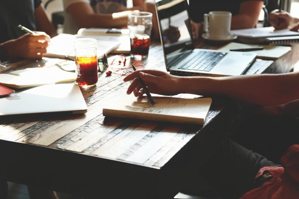 Team meeting around a table with laptops